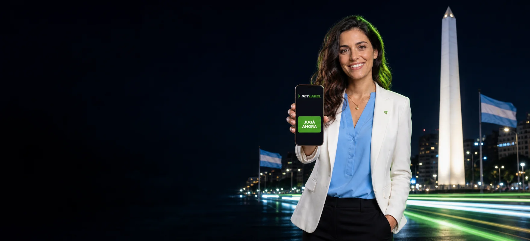 Mujer de saco blanco que muestra un celular con la app de BetLabel frente al Obelisco de Buenos Aires de noche Mujer de saco blanco que muestra un celular con la app de BetLabel frente al Obelisco de Buenos Aires de noche